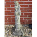 A pre-cast garden ornament in the form of a girl sat upon a short column, 82cm high.