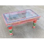 A colourfully painted Indian style coffee table having iron work centre with glass top, 94 x 57.