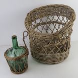 A wicker log basket together with a wicker covered green glass bottle. Two items.