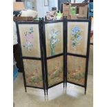 An antique three fold screen having three hand painted silk flower panels above three printed