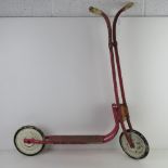 A vintage Triang child's scooter having original wheels and handles approx 75cm high.