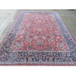 A 100% wool rug in red and navy ground having floral pattern,