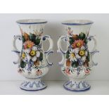 A pair of white ground continental style vases having floral decoration upon and each standing 32.