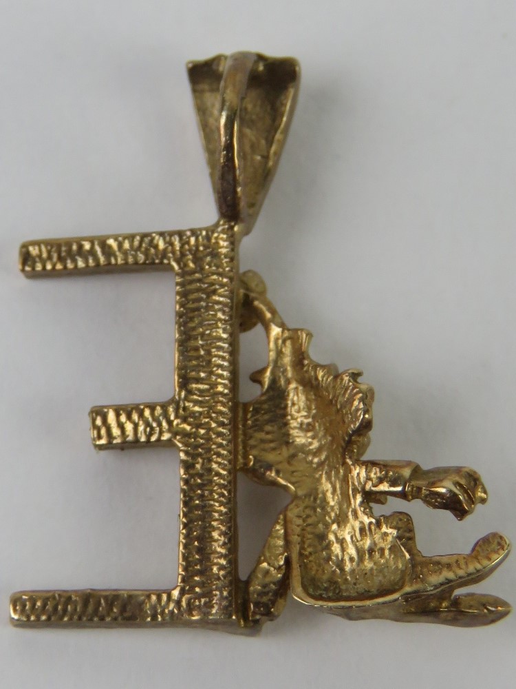 A 9ct gold pendant in the form of an 'E' with clown figure leaning upon, 2cm in length, 1.2g. - Image 2 of 2