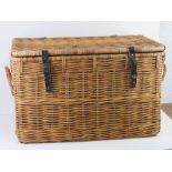 A large coffee table sized lidded wicker hamper having end handles and leather straps approx 72 x