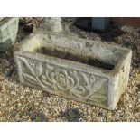 A pre-cast stone planter having tulip and rose decoration upon, 61cm wide.