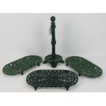 Green painted cast iron kitchen items including three trivets.