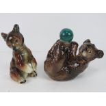 A pair of ceramic bear figurines, one playing with green ball, one marked to base CW39.