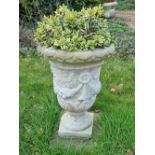 A pre-cast stone urn 58" high.