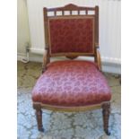 A single low Edwardian fireside or nursing chair having floral inlay, oversprung seat,