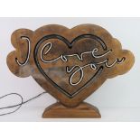 A wooden heart shaped neon light 'I Lov