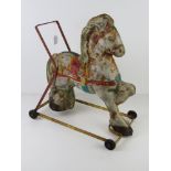 A vintage tin plate child's walker in the form of a show ground pony.