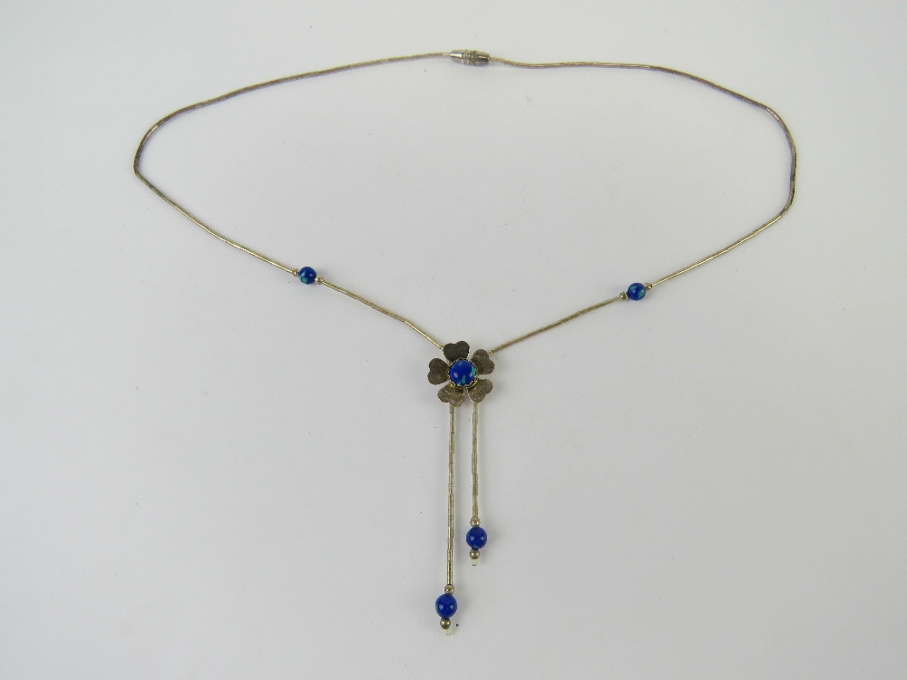 A Native American style silver beaded necklace having blue stone set floral design, marked Sterling.
