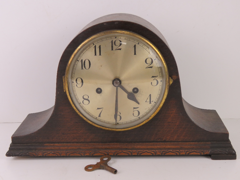 A c1930 oak cased mantel clock with winging key.