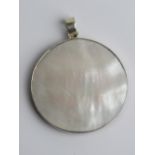 A double sided silver pendant, red hardstone and mother of pearl, 4cm wide.