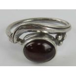 A handmade garnet ring in the Arts and Crafts style, no apparent hallmarks, size L-M.