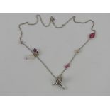 A silver necklace having hummingbird pendant, pearl, crystal and floral decoration upon,