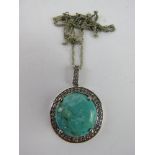 A silver and turquoise pendant having CZ stone surrounding the central cabachon, total diameter 4.