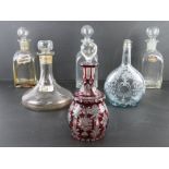 A ruby glass decanter with clear glass stopper together with a quantity of other decanters and