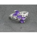 A 9ct white gold and amethyst ring having five marquise stones in floral spray setting,