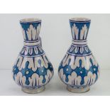 A pair of pottery vases in blue and white ground, each standing 22cm high.