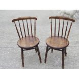 A good pair of circular seated spindle back chairs raised over ring turned legs, each 41cm dia.