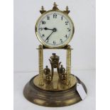 A brass clock on stand having white enamel dial, blue steel hands, a/f, dome deficient.