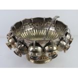 A large and impressive silver plated punch bowl with eleven cups and associated punch ladle,