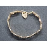 A 9ct gold four bar gate link bracelet having heart padlock clasp, hallmarked 375, 4.5g.