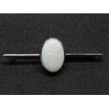 A 9ct white gold opal brooch, the large central oval cabachon approx 16 x 11mm,