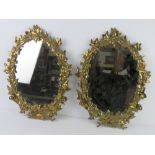 A pair of heavy brass framed wall mirrors having ivy design, each approx 48 x 36cm.