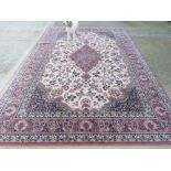 A 100% wool rug in red, cream and navy ground having floral pattern, approx 344 x 248cm.