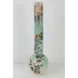 A tall Japanese Meiji period vase handpainted bird and floral decoration upon a pale green ground,