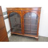 A fine Edwardian walnut twin glazed door bookcase raised over short cabriole legs,