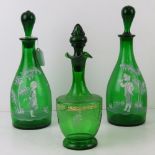 A pair of Mary Gregory style green glass decanters standing 30cm high together with another.