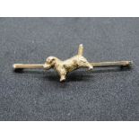 A heavy early 20th century bar brooch having cast figure of a dog upon,
