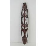 A contemporary wooden wall mask carving measuring 55cm in length.