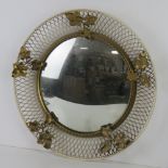 A mid century wall mirror having applied ivy leaf design and convex glass, 43cm dia overall.
