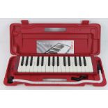 A Horner Melodica Student 32 in red, as new in case with instructions.