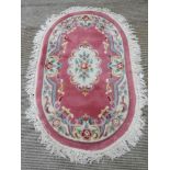 An oval woolen rug, 115 x 120cm.