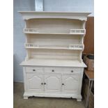 A 20th century cream painted Welsh dresser having twin shelves with pediment over,