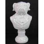 A white ceramic bust having suited male shoulders with bulldog head upon.