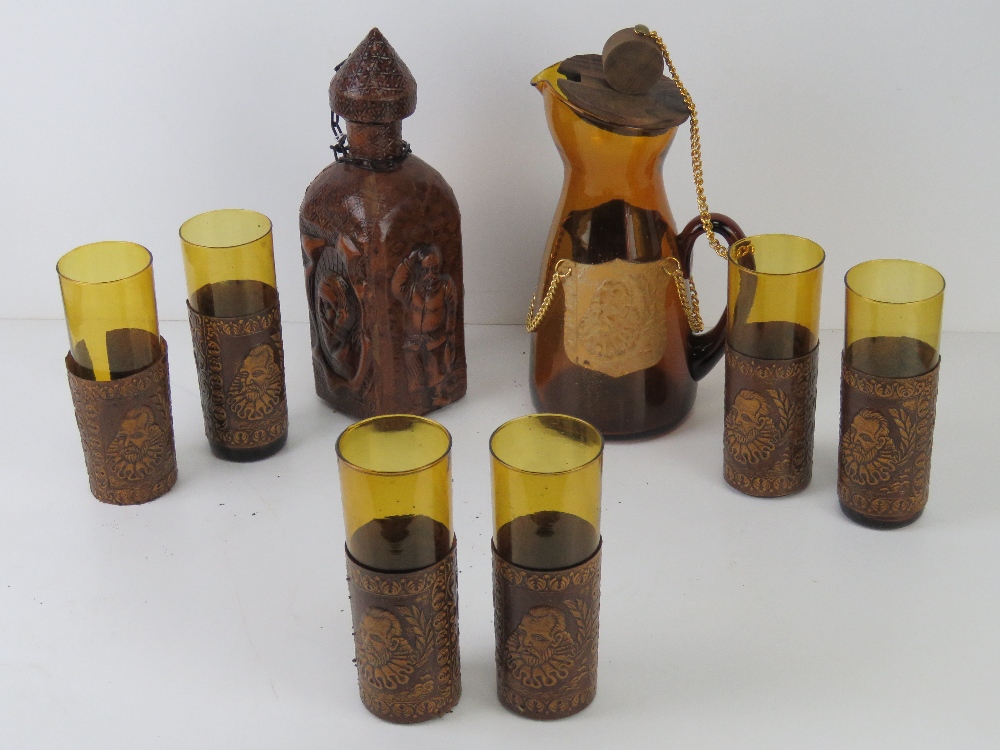 A set of six leather covered glasses with matching decanter and similar leather covered amber glass