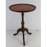 A red leather topped occasional or wine table.