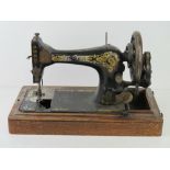 A Singer sewing machine in wooden base, lid deficient, F5606585.