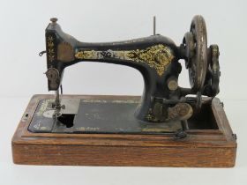 A Singer sewing machine in wooden base, lid deficient, F5606585.