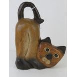 A carved and painted wooden figuring of a cat standing 23cm high.