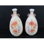 A pair of blush ground vases having floral decoration upon and standing 22cm high. One slightly a/f.