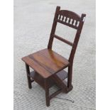 A Victorian oak metamorphic set of library steps folding to form a chair. Height of seat is 44cm.