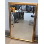 A large contemporary bevelled edge wall mirror in gold painted frame measuring 100 x 68.5cm.